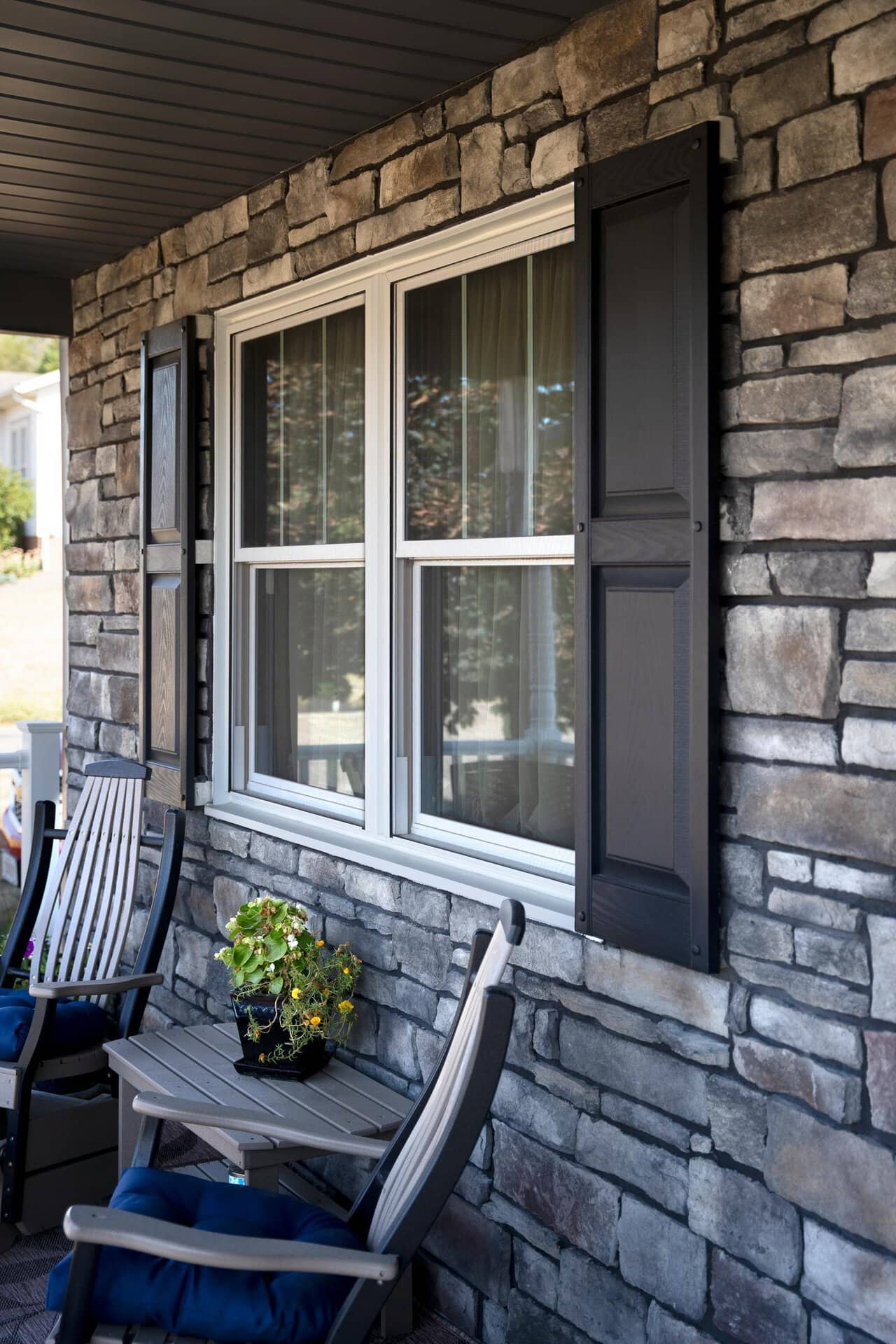 ProVia Aeris double-hung window with shutters on a stone porch